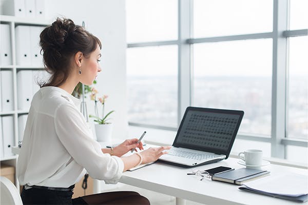 Rear-view-portrait-of-a-businesswoman-sitting-on-her-workplace-in-the-office